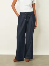 Jean de corte wide leg en color azul oscuro, con cintura elástica ajustable mediante cordón y cierre frontal con botón.