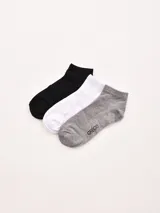 Pack de tres pares de medias tobilleras de algodón, en colores negro, blanco y gris jaspeado. La media gris tiene la palabra "GREGO" estampada en el empeine.