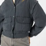 Campera bomber azul petróleo acolchada con cuello redondo, cierre con botones a presión, bolsillos con solapa y puños y cintura elásticos.