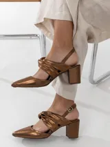 Zapato de cuero color bronce, con punta fina, taco cuadrado y pulsera con hebilla dorada.