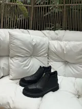 Botas cortas de cuero con suela cosida de 3 cm y cierre superior. Cuentan con dos elásticos al costado escondidos en el cuero para facilitar su uso y asegurar comodidad.