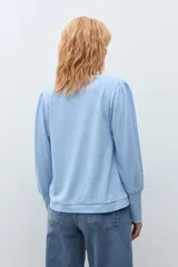 Remera de manga larga con diseño de hombros abullonados y cuello redondo, confeccionada en tejido de punto suave.