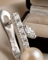 Caravanas de plata 925 con diseño de aro pequeño adornado con circonias y una perla colgante.