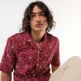Camisa de manga corta confeccionada en mezcla de lino, color bordó, con cuello cubano y diseño estampado de flores en trazos blancos.