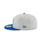 Gorra gris con visera azul, logo de los Golden State Warriors bordado en el frente y logo de New Era bordado en el lateral.