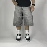 Bermuda de jean negro con corte ancho y largo hasta la rodilla.