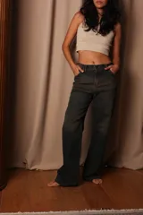 Pantalón de jean de tiro alto con lavado oscuro y detalles de desgaste.