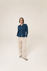 Camisa azul de punto 100% algodón con cuello polo, manga larga y cierre frontal con botones.