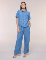 Camisa de corte recto y calce fluido color celeste, confeccionada en lyocell, con cuello camisero clásico, mangas cortas y bolsillos plaqué en el pecho.