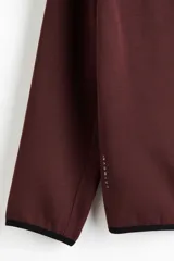 Campera deportiva de tejido funcional con efecto neopreno, con capucha, cierre frontal y bolsillos laterales con cierre. Presenta mangas raglán y terminaciones elásticas en puños y bajo.