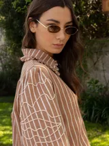 Camisa celeste de denim con bordado de hojas en las mangas, cuello con volados y botones de flor.