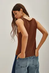 Top de punto color beige, con escote en U pronunciado y textura sedosa y brillante.