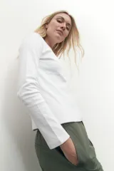 Remera de manga larga color blanco, con cuello redondo y calce al cuerpo.
