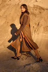 Abrigo largo tipo bata con diseño envolvente y cinturón de cuero. Presenta mangas acolchadas con patrón capitonado, cuerpo de tweed con vivos de cuero y solapa con detalle de corderito.