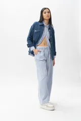 Pantalón pijama de algodón a rayas verticales celestes y blancas, con cintura elástica y seis bolsillos.