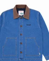 Campera estilo workwear de Denali, confeccionada en canvas resistente color azul medio. Presenta cuello de pana en tono marrón, cierre frontal con botones metálicos y dos bolsillos frontales amplios. Incluye bordado de la marca en el pecho.
