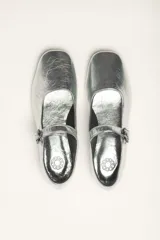 Zapato plano estilo Mary Jane de cuero negro, con punta fina y tira ajustable con hebilla sobre el empeine.