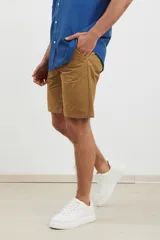 Bermuda de gabardina color tostado, con corte recto, bolsillos laterales y cierre frontal con botón.
