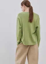 Jersey de punto color verde claro, con escote en V y mangas largas de corte holgado.