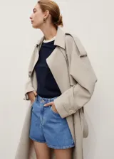 Short de denim azul medio, de tiro alto y diseño recto con cinco bolsillos, trabillas para cinto y cierre frontal con cremallera y botón.