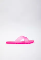 Sandalia chata de goma semi transparente color fucsia, con doble tira entrelazada sobre el empeine.