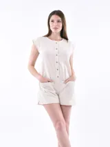 Monoprenda corta de lino color beige, con cuello redondo, cierre frontal con botones y bolsillos delanteros tipo parche.