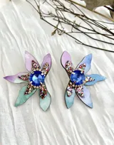 Par de aros colgantes con forma de flor, hechos con pétalos de cuero sintético en degradé de colores (lila, celeste y verde agua) y centro con strass azul y glitter.