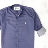 Camisa de hombre azul marino con rayas verticales finas blancas, cuello mao, cierre con botones marrones y logo bordado en el pecho.