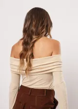 Blusa beige con hombros descubiertos, mangas largas acampanadas y confeccionada en tela stretch con lurex.