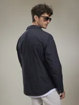 Campera casual liviana de nylon, con cierre frontal de botones a presión, cuello camisero y bolsillos frontales tipo parche.