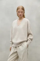 Sweater de cuello en V, color beige, con detalles acanalados y confeccionado con lana 100% reciclada.