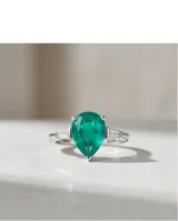 Anillo de plata con piedra central verde en talla gota y detalles de circones laterales en talla baguette.