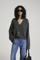 Cárdigan gris de tejido de punto con bolsillos delanteros y mangas anchas.