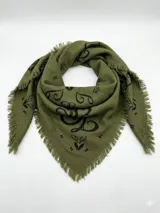 Bandana de forma triangular en color verde oliva con estampado floral en negro y bordes desflecados.