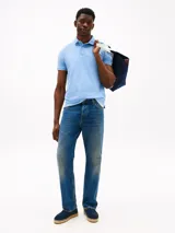 Chomba celeste de piqué de algodón con cuello clásico, tapeta de dos botones y logo de Tommy Hilfiger bordado en la manga.