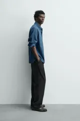 Camisa regular fit de denim de algodón azul, con cuello solapa, manga larga con puños abotonados, un bolsillo de parche en el pecho y cierre frontal de botonadura.
