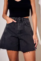 Bermuda de jean estilo wide leg, color negro lavado, con tiro medio, bolsillos laterales y ruedo desflecado.