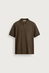 Polo regular fit color marrón, confeccionado en tejido de algodón con textura de rayas verticales. Cuenta con cuello solapa, cierre frontal de dos botones y mangas cortas con acabado en rib.