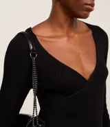 Blusa negra de punto acanalado, con escote en V profundo y mangas largas.