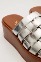 Sandalias marrones de cuero con plataforma pareja. Diseño con tiras de cuero tejidas en la parte superior y suela ancha que aporta estabilidad y comodidad.