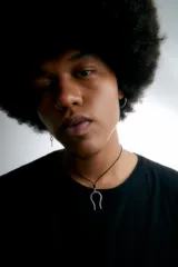 Collar con cordón negro ajustable y dije de acero quirúrgico hipoalergénico con forma de herradura invertida.