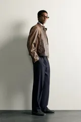 Pantalón relaxed fit azul marino confeccionado en tejido con lana, con bolsillos frontales, bolsillos traseros de doble vivo y pliegues en la parte delantera.
