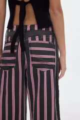 Jean baggy de tiro alto en color celeste con estampado de rayas verticales negras, corte holgado y paneles laterales en denim negro.