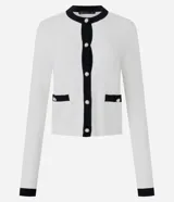 Cardigan de punto color blanco con detalles en negro en cuello, puños y tapeta frontal. Presenta cierre frontal con botones perlados y dos bolsillos delanteros falsos con solapa bicolor.