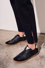 Pantalón de jean negro, de corte recto y tiro medio, con cierre frontal de botones.