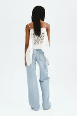 Jean wide leg de tiro alto en denim de algodón celeste claro, con diseño de cinco bolsillos, cierre de cremallera y botón metálico.