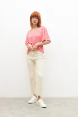 Remera fucsia de canalé con escote en V y mangas cortas con volados.