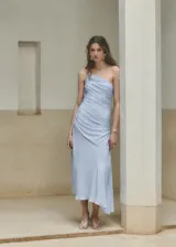 Vestido midi color celeste con diseño evasé, cuello asimétrico de un solo hombro con tirante fino, cuerpo fruncido y cierre de cremallera lateral.