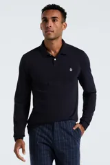 Polo de manga larga color negro, confeccionada en tejido otoman, con cuello clásico y cierre frontal de dos botones. Presenta el logo de la marca bordado en el pecho.