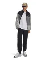 Pantalón deportivo tipo jogger Under Armour, color negro con franjas laterales en gris y blanco. Presenta cintura elástica con cordón interno, bolsillos laterales, bolsillo trasero con cierre y puños elásticos en los tobillos.